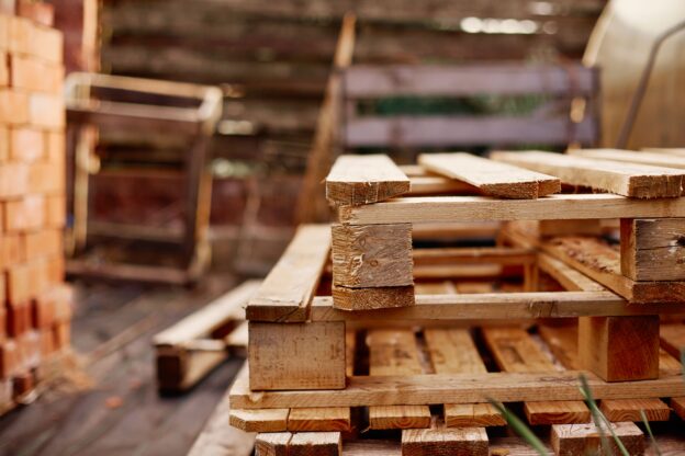 Pallets com longarinas empilhados em galpão logístico